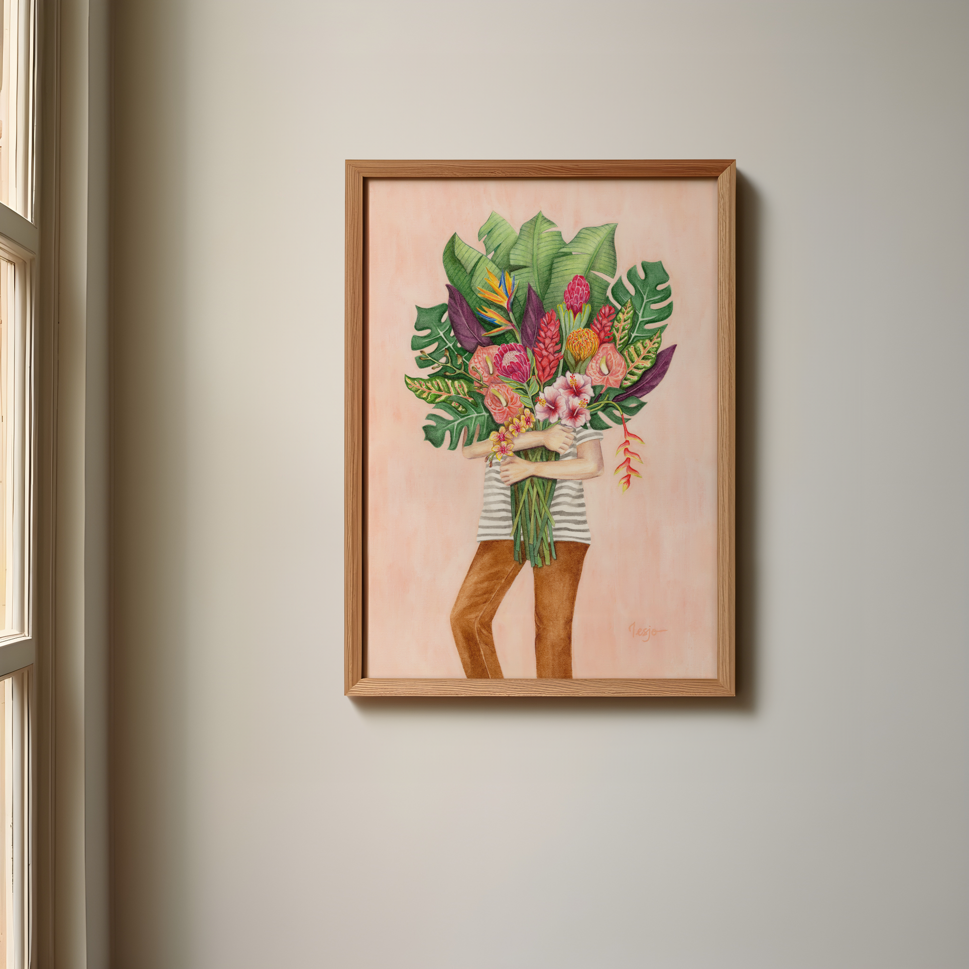 Framed artwork of a person holding tropical plants and flowers against a light pink background, hanging on a wall.